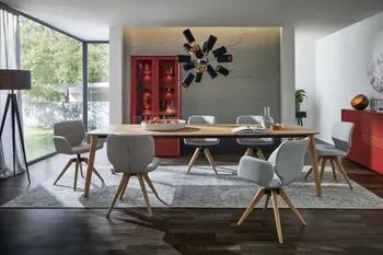 Großer moderner Esstisch aus hellem Holz, um den sechs Stühle mit grauem Stoffbezug stehen mit und ohne Armlehne und hellem Holzgestell.